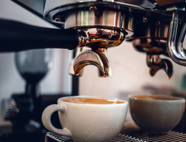istock Espresso coffee extraction from a professional coffee machine with a bottomless filter, Close-up of a coffee drop  from the coffee machine 1501136063