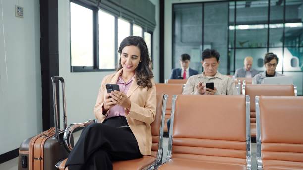istock The passengers, tourist using smartphone while sitting on chair in terminal hall waiting flight in the departure gate at international airport. Travel concept 1501140770