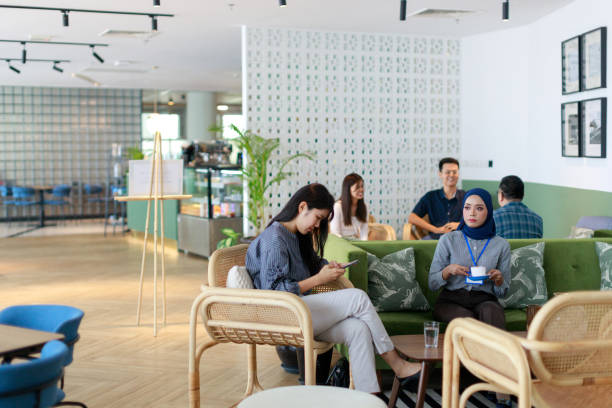 istock A diverse group of people, representing different Asian ethnicities, sits in a modern office cafeteria, enjoying their free time and relaxing during a coffee break. 1501141521
