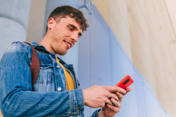 istock Cheerful man using smartphone on street 1501141776