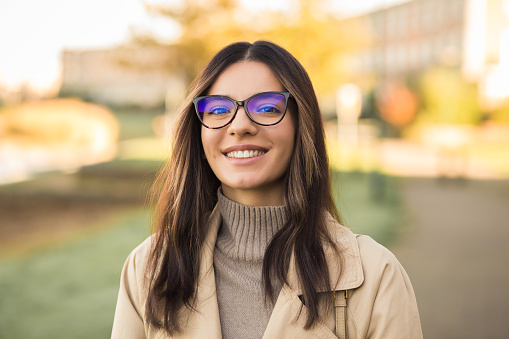 Close up portrait smiling newly admitted student multiethnic female wearing glasses in front of university.