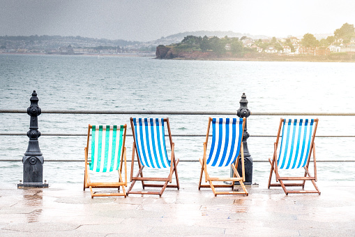 Experimental edit of abandoned deck chairs on the promenade at Torquay in torrential rain