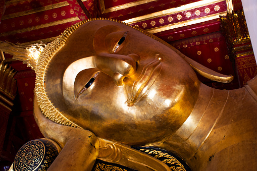Ancient antique buddha reclining attitude statues of Wat Pa Mok Worawihan temple for thai people travelers travel visit and respect praying blessing wish holy mystery worship in Ang Thong, Thailand