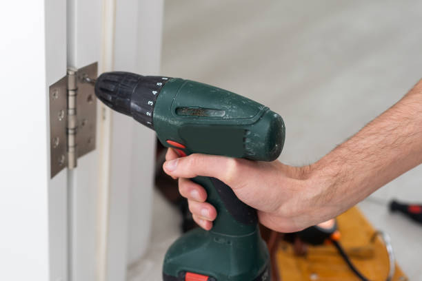 istock Screwing hinge installation on a process of wood door 1501145160