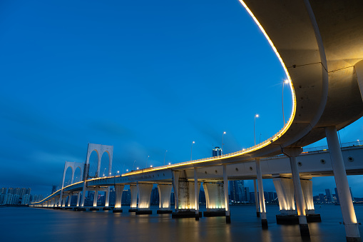 A close-up night view of the curved bridge on the sea, connecting the world economy. Partial close-up of Sai Van Bridge in Macao