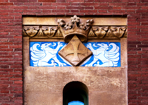 Shot in color detail on the facade of this historic building representing some character, animal or flower.