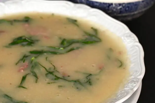 Photo of green soup, herbal cream with cassava vegan food natural healthy food with wine in the background.