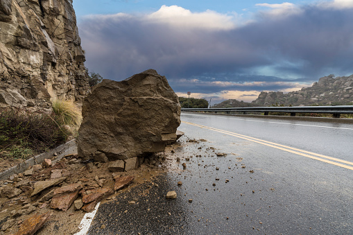 Rainy road rockslide blocking traffic lane on Santa Susana Pass Road in the Chatsworth area of Los Angeles, California.