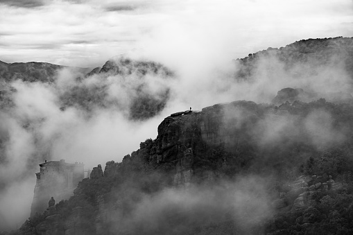 Meteora monastery complex, Greece. Orthodox monastery on the rock, emerging from morning mist, UNESCO site, Greece.