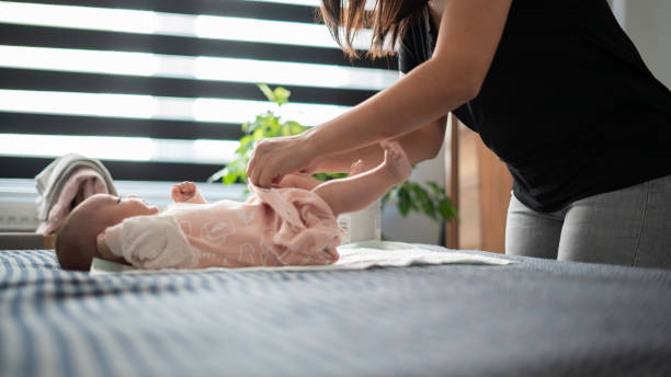 istock Mom changes her baby's dirty diaper in the bedroom 1501168760