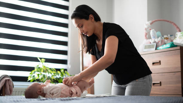 istock Mom changes her baby's dirty diaper in the bedroom 1501168793