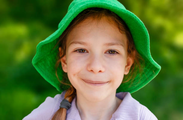 Cheerful child girl in green panama. Summer portrait. Girl Outdoors