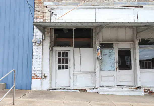 The storefront of an abandoned barber shop in Fordyce, Arkansas with blue and white colors