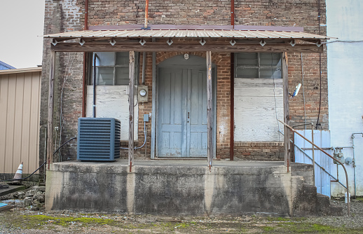 The rear entrance to an abandoned building with blue double doors in Hayneville, Louisiana