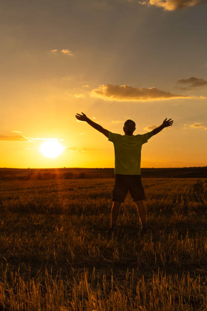 istock A man with his arms outstretched watching and enjoying the sunset. Vertical. 1501182786