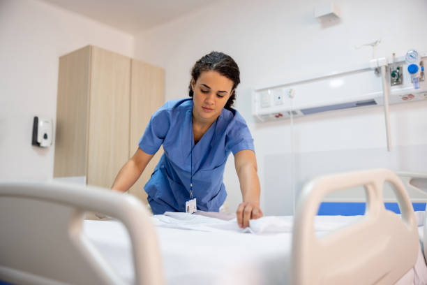 Nurse making a bed in a hospital room