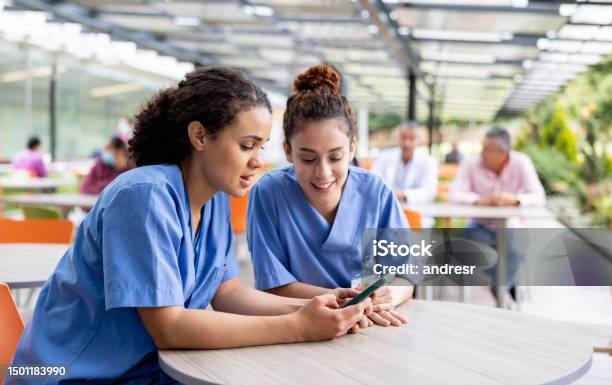 Nurses Taking A Break And Looking At Social Media At The Cafeteria Stock Photo - Download Image Now