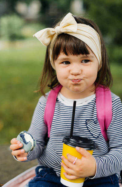 istock funny girl drinks cocoa and eats macaroon 1501185354
