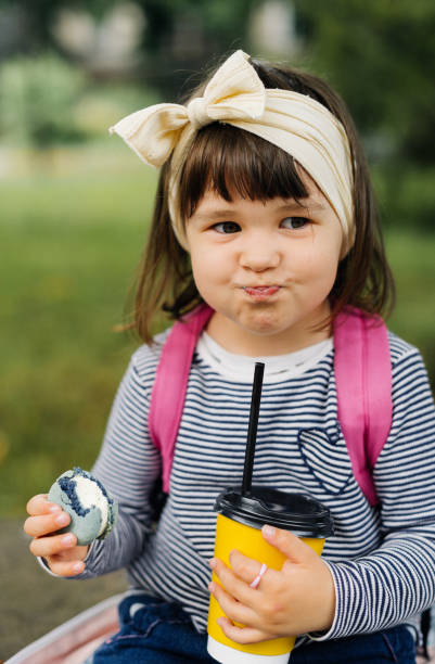 istock funny girl drinks cocoa and eats macaroon 1501185363