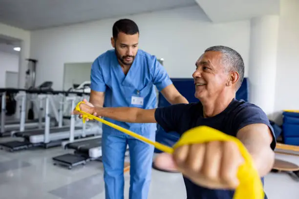 Photo of Man doing physical therapy exercises using a stretch band