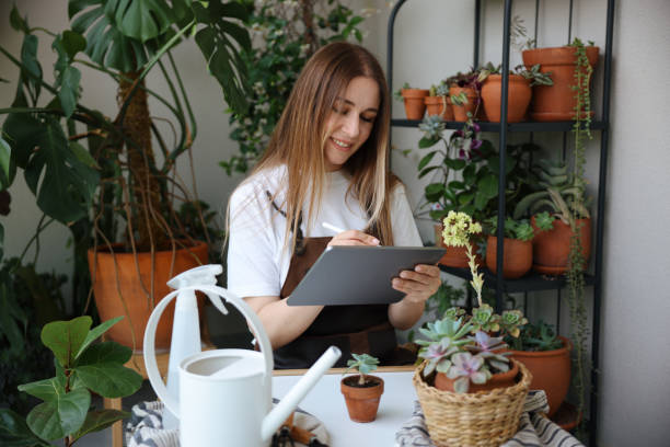 istock Smiling young woman posing with digital tablet surrounded by houseplants 1501185935