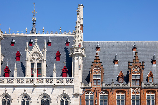 Bruges, Belgium - May 19, 2023: Facades of historical buildings of Post Office (Posterjen) and Provincial Court (Provinciaal Hof) at Main Market Square (Grote Markt)