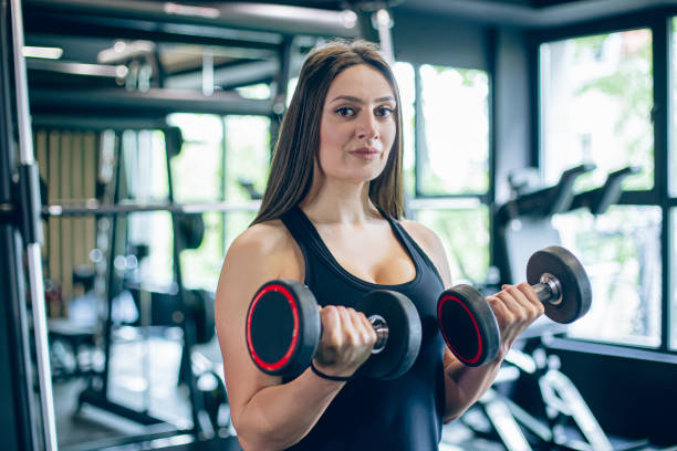 istock Young woman training in gym with dumbbells 1501187483