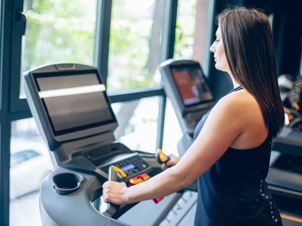 istock Young woman using the treadmill in the gym 1501187685
