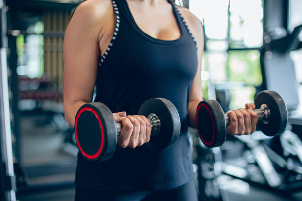 istock Young woman training in gym with dumbbells 1501188830