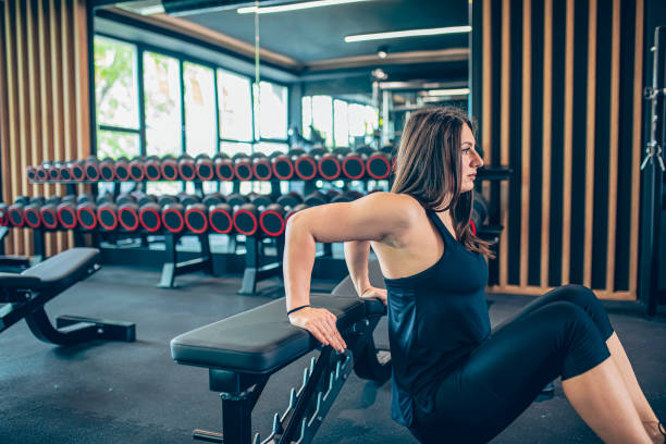 istock Young woman working triceps dips in gym 1501189836