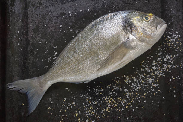istock Fresh raw fish of sea bream on black baking sheet. Flat lay 1501190158
