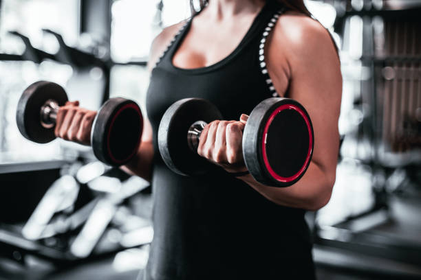 istock Young woman training in gym with dumbbells 1501190226