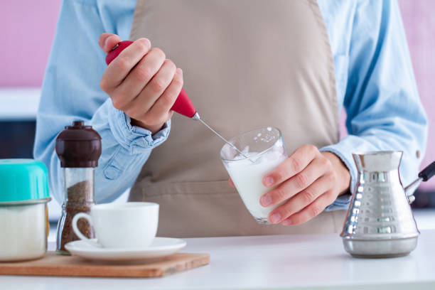 istock Woman in apron making coffee with using a milk frother at kitchen at home 1501193152