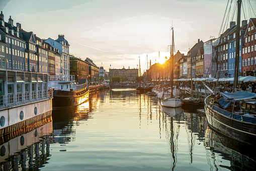 Saiboats in  harbor: landmark of Copenhagen Nyhavn, boats in sunset. Fantstic place to walk and sit in cafe