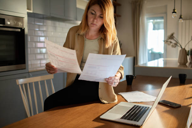 istock Young woman going over her finances at home while using her laptop 1501198102