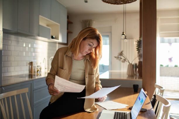 istock Young woman going over her finances at home while using her laptop 1501198399