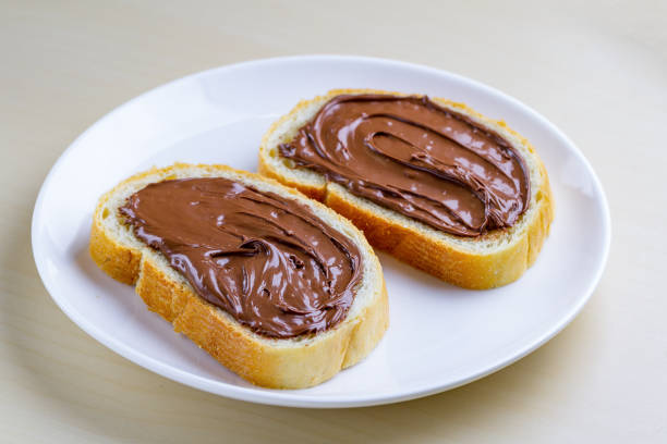 istock Pieces of long loaf with chocolate, nut paste on a plate. Nut chocolate cream sandwich with nut butter on a breakfast 1501200222