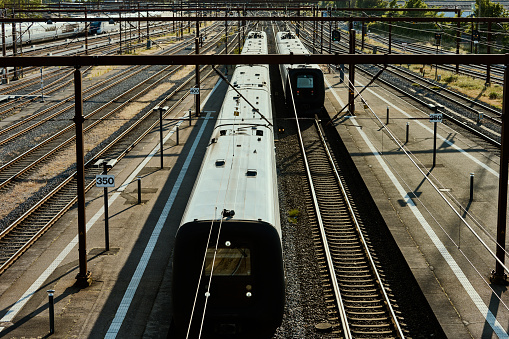 Train arriving at station and one leaving. High angle view.