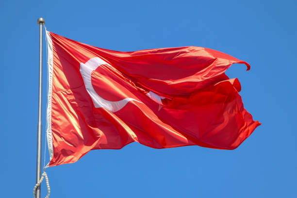 istock Waving Turkish flag. Sky background. Flag with star and crescent symbol 1501202721