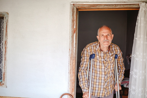 Senior man enjoying retirement days at home standing at the door