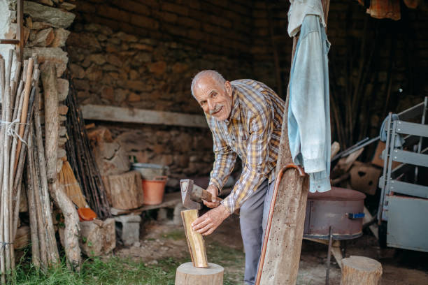istock Old man spending time home alone holding axe and chopping woods 1501204105