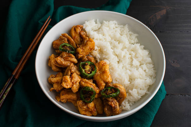 Crispy Hawaiian Garlic Chicken Served with Jasmine Rice Fried chicken thighs in garlic-soy sauce served with fried jalapeno peppers and white rice jasmine rice stock pictures, royalty-free photos & images