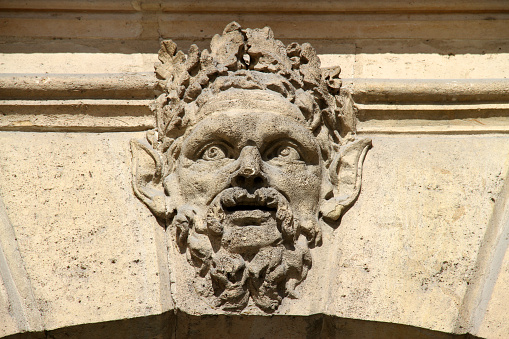 A carved face on a wall in the heart of Paris