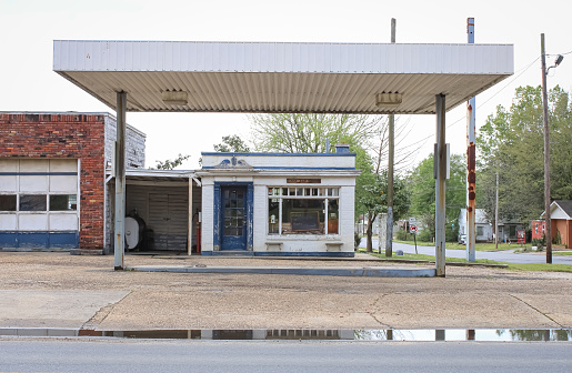 An abandoned service station in Fordyce, Arkansas with a blue door and a chalk sign in the window