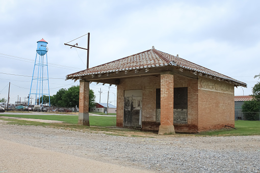 The townscape of Belleview, Texas on a stormy day with an abandoned service station and a water tower