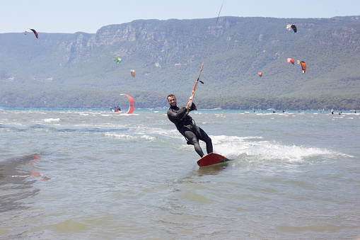 Kiteboarding, Kitesurfing. Water Sports. Professional Kite Surfer In Action On Waves In Ocean. Extreme Sport. Healthy Active Lifestyle. Hobby. Recreational Sporting Activity. Summer Fun, Adventure