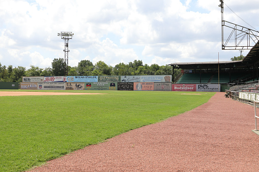 Athlete with baseball in hand, man holding ball on outdoor sports field or pitch in New York stadium. American baseball player's catch, exercise fitness with homerun or retro sport bokeh background