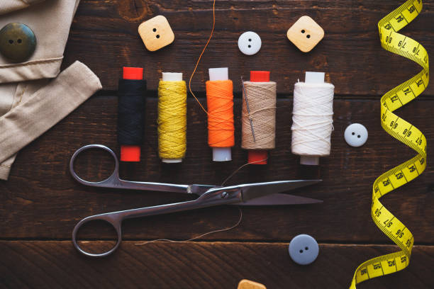 istock Spools of thread and sewing kit for tailoring on wooden background. Top view 1501250736