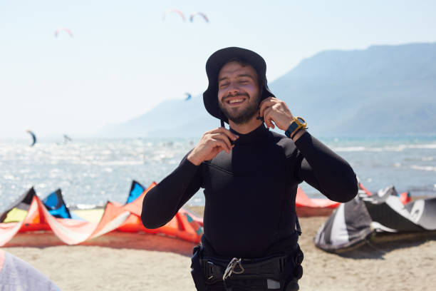 Young man completing his preparations for kiteboarding with positive expression on the beach