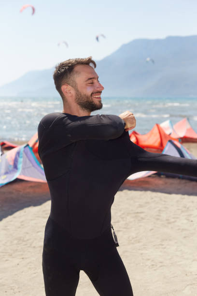 A man is preparing for kiteboard on the beach